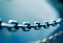 Primo piano di una catena in acciaio con gli anelli in tensione lungo una linea
