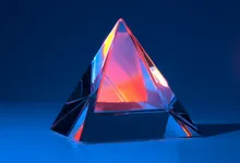 Prisma di vetro che scompone la luce in riflessi rossi e blu
